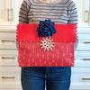 Flat lay of EverWrap EverEnvelope medium reusable gift bag in red and white, folded and compact for storage