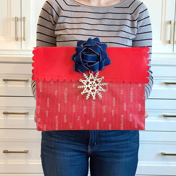 Flat lay of EverWrap EverEnvelope medium reusable gift bag in red and white, folded and compact for storage