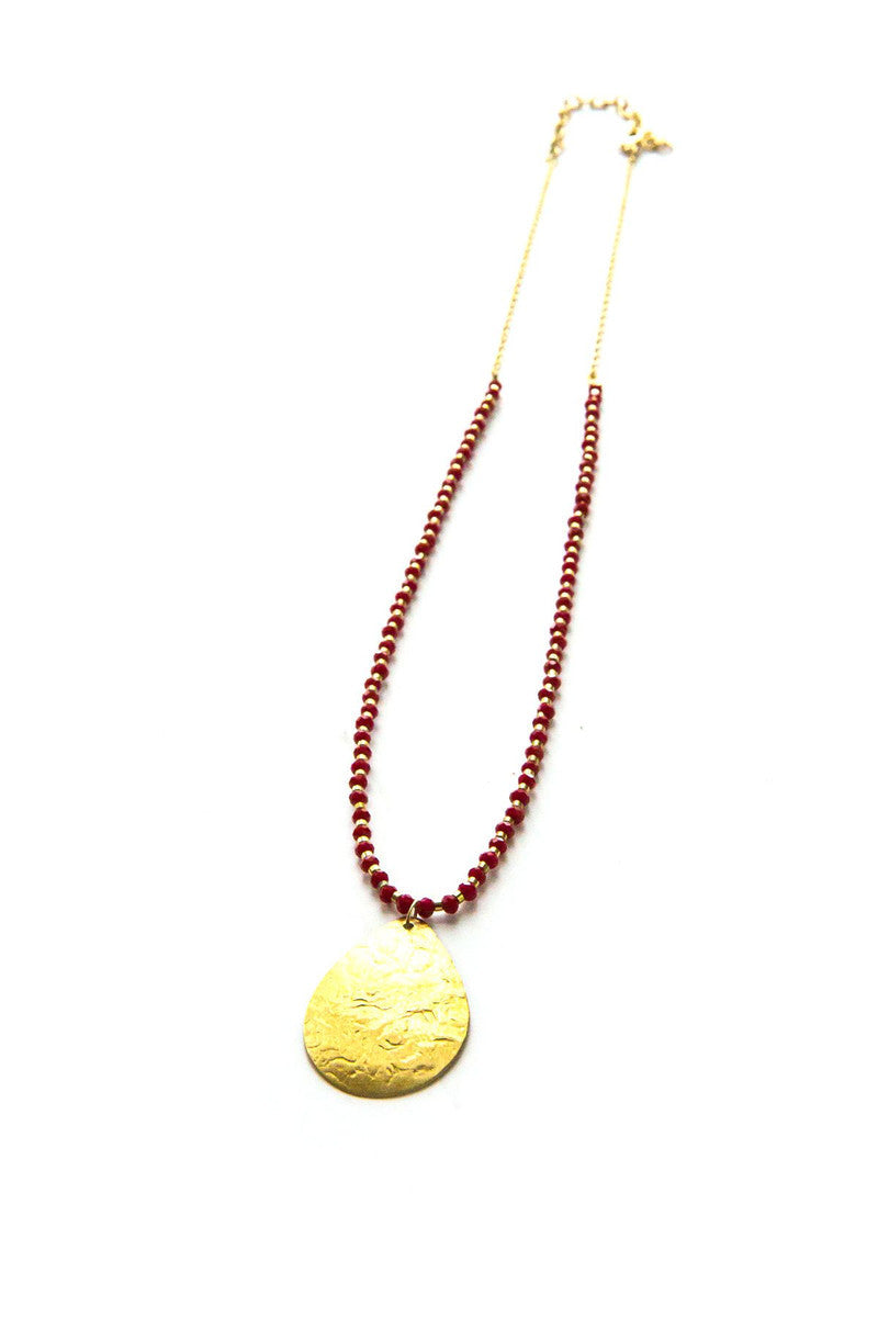 Red beaded pendant necklace styled on model, showing full necklace length