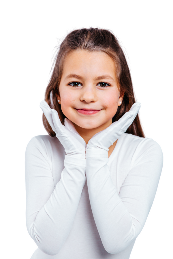 Young girl wearing white gloves against a white background. Remedywear kids eczema gloves with TENCEL & zinc oxide — dermatologist recommended, Oeko-Tex certified & made in Portugal. Soothe itchy skin day & night. Shop now.