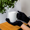 Adult wearing black Remedywear eczema gloves while holding a mug, showing comfortable everyday fit for psoriasis and eczema on hands