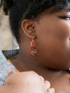 Close-up of rustic natural fiber woven earrings in rust colour by Fair Anita