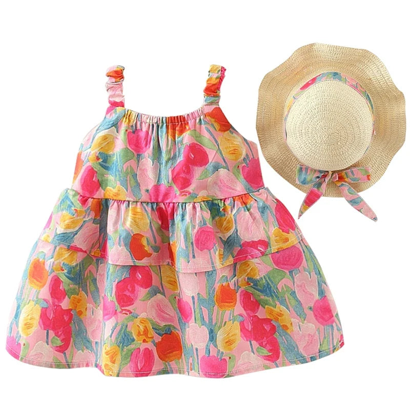 A toddler girl's tiered dress with a colorful floral print, shown alongside a matching straw sun hat with a floral ribbon, on a solid white background.