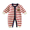 A baby long-sleeve knit romper with red and off-white horizontal stripes, a navy blue collar and front placket, and a small tan bear patch on the chest, laid flat against a light gray background.