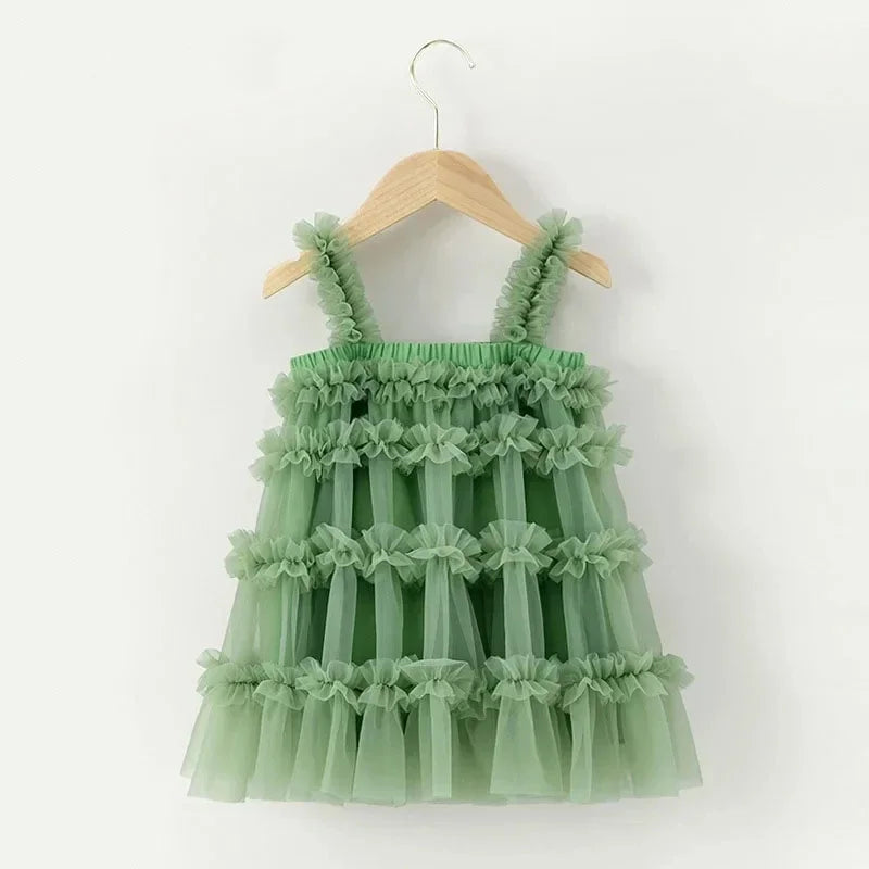 Green ruffled dress on a wooden hanger against a white background