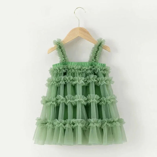 Green ruffled dress on a wooden hanger against a white background