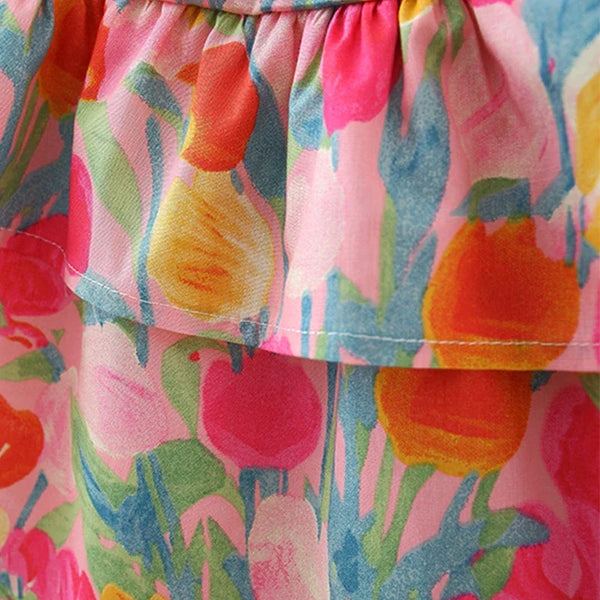 Close-up of a tiered ruffle skirt featuring a colorful watercolor tulip print in pink, orange, yellow, and green.