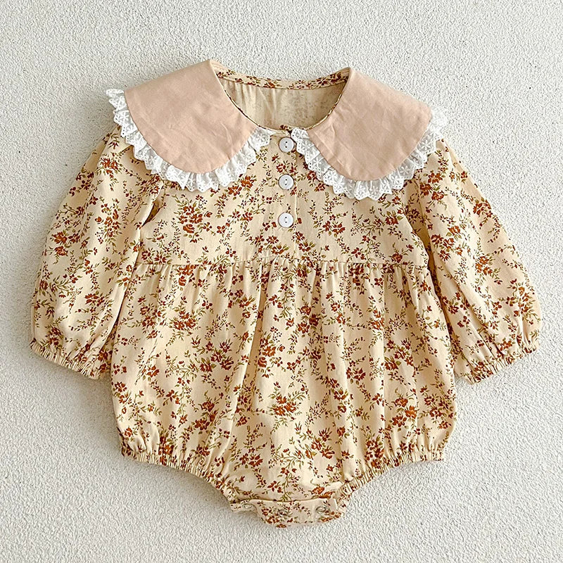 Floral baby romper with lace collar on a light background