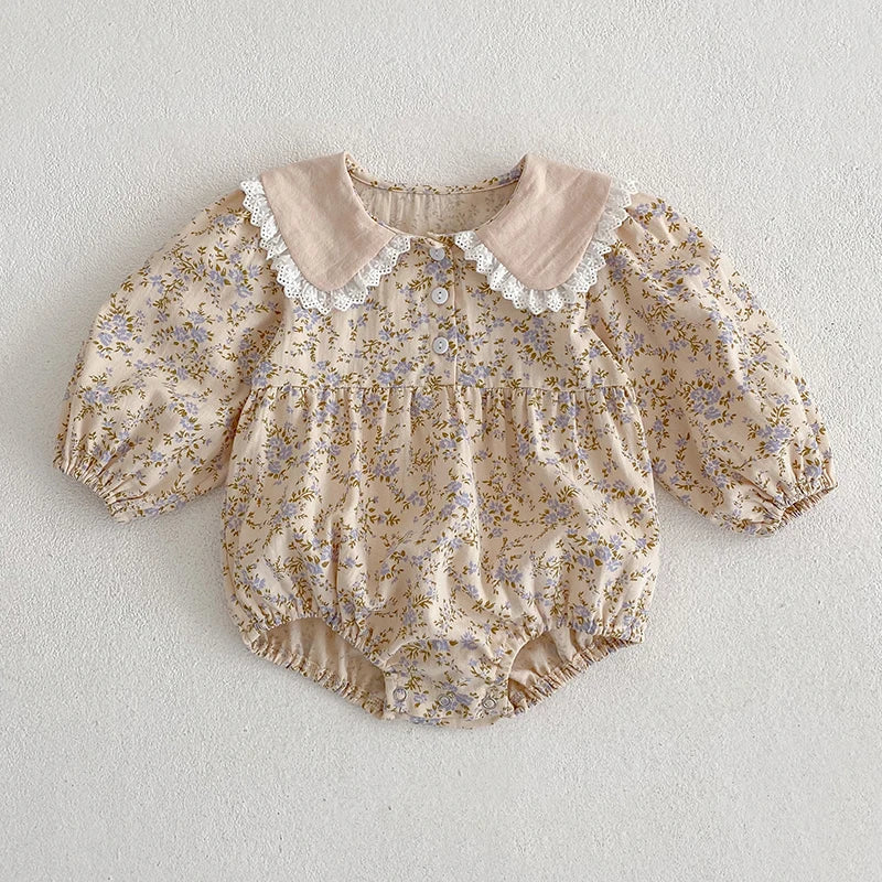Floral baby romper with lace collar on a light gray background