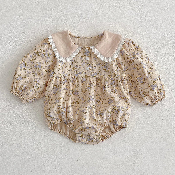 Floral baby romper with lace collar on a light gray background