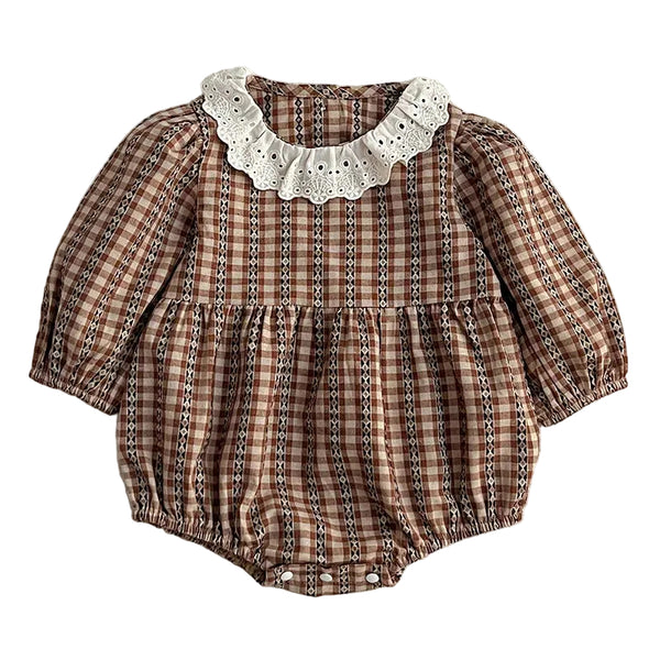 A baby romper with a brown and beige gingham pattern, featuring a white eyelet lace collar and a gathered ruffle waist, laid flat on a textured white background.