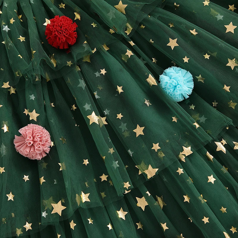 Green fabric with gold star patterns and colorful pom-poms.