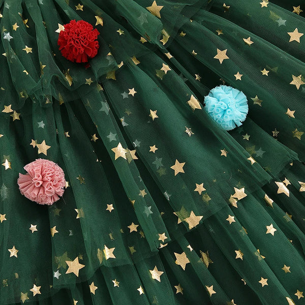 Green fabric with gold star patterns and colorful pom-poms.