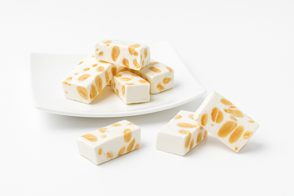 Close-up of sugar-free almond brittle nougat pieces showing whole roasted almonds embedded in crystalline brittle