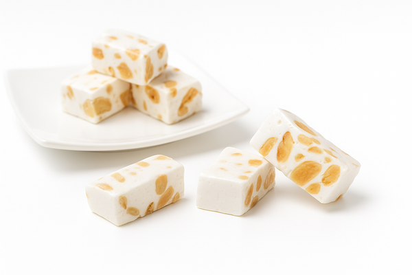 Andy Anand gluten-free almond nougat brittle pieces arranged on a surface, highlighting crunchy texture and whole almonds