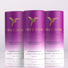 Three purple 'Freedom' Magic Lavender natural deodorant bottles on a light gray background