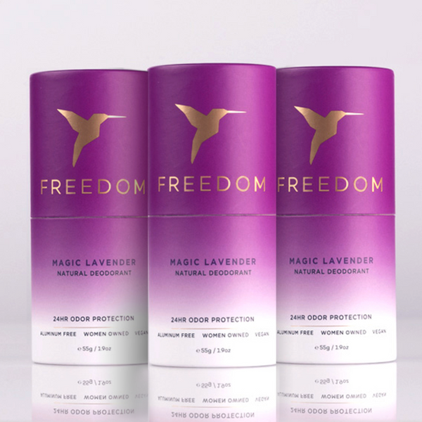 Three purple 'Freedom' Magic Lavender natural deodorant bottles on a light gray background