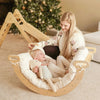 Woman and child in a wooden rocking chair with a Christmas tree in the background