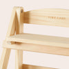 Wooden chair with 'TINY LAND' branding on a light pink background