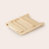 Wooden folding step stool on a light beige background