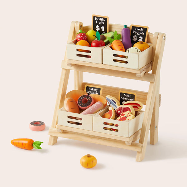 Wooden toy grocery stand with toy fruits, vegetables, and meats on a white background