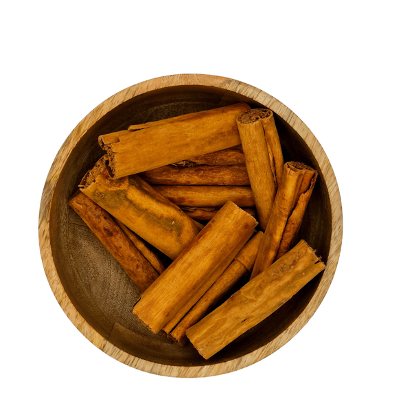Wooden bowl filled with cinnamon sticks on a white background
