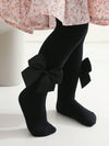 Black knee-high socks with a large bow worn by a person, on a white background