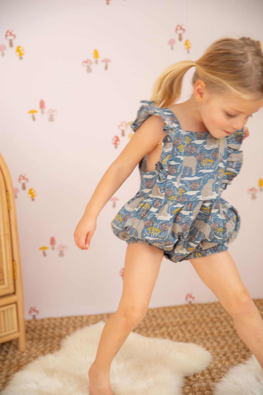 Close-up of Safari Party organic cotton muslin flutter sleeve romper showing print detail and snap closure