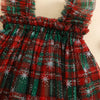 Red and green plaid dress with white star patterns on a beige background
