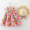 A toddler girl's tiered floral dress with a straw hat, displayed on a wooden hanger and a straw stand against a plain white background.