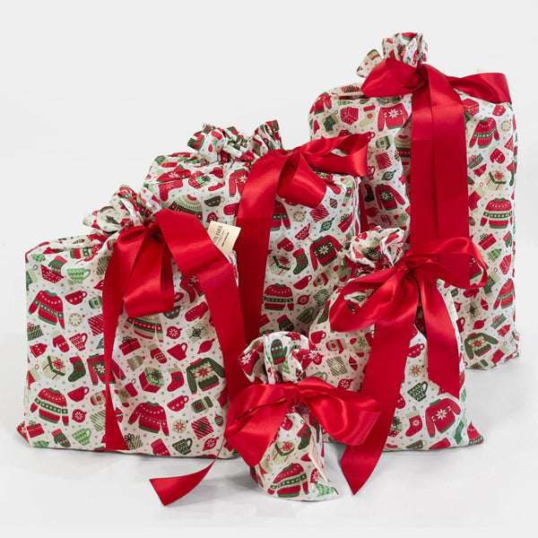 Set of Christmas-themed gift bags with red ribbons on a white background