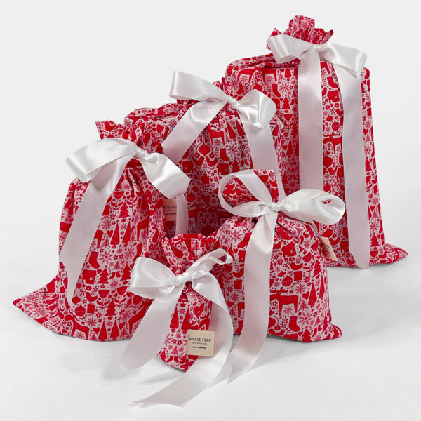 Red patterned gift bags with white ribbons on a white background