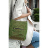 Person holding a green bag with a blurred background