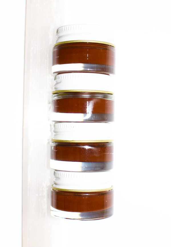 Stack of brown jars with white lids on a white background