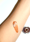 Lip balm swatch on a person's arm with a close-up of the lip balm container.
