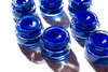 Multiple SEA Creature blue spirulina lip balm glass jars with lids on a white background