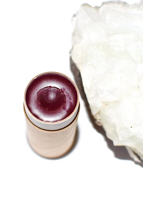 Lip balm with a white flower on a white background