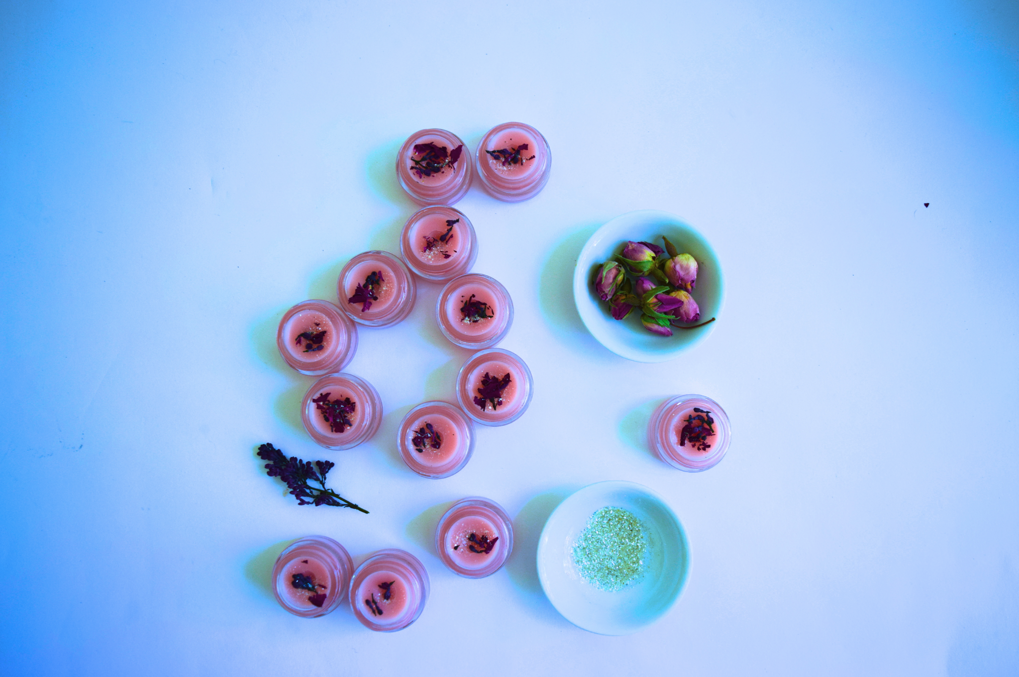 Decorative setup with pink jelly-like containers and small bowls on a gradient blue background