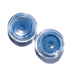 Two small jars of blue glitter on a white background