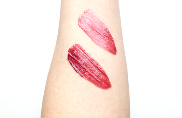 Two pink lipstick swatches on a person's arm against a white background