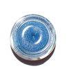 Small jar of blue glitter on a white background