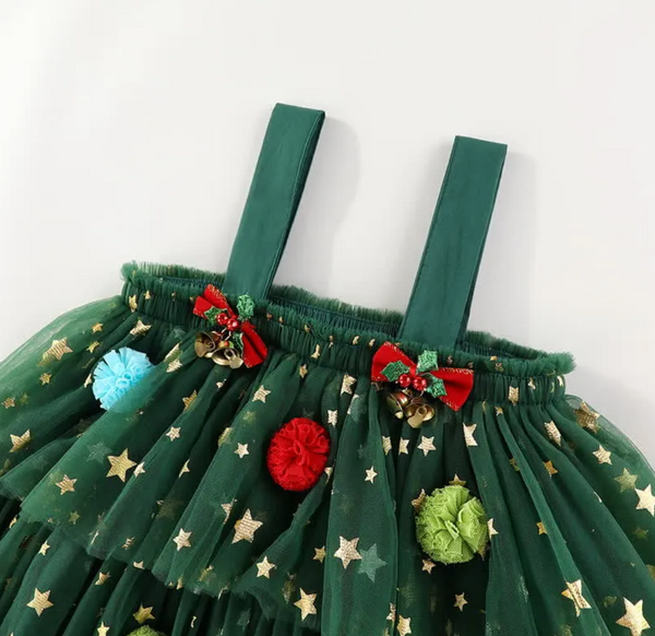 A green tutu skirt decorated with gold star patterns, red and green pom-poms, and small red bows with gold bells, shown against a plain white background.