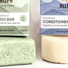 Green soap bar and bottle of conditioner with 'All for Alpha' branding on a light background