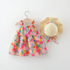 Colorful floral dress on a hanger with a matching straw hat on a white background