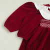 Red dress with white collar and embroidery on a light background