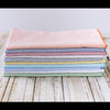 Close-up of seersucker cloth napkins in assorted colors stacked together, highlighting the cotton blend fabric and puckered texture