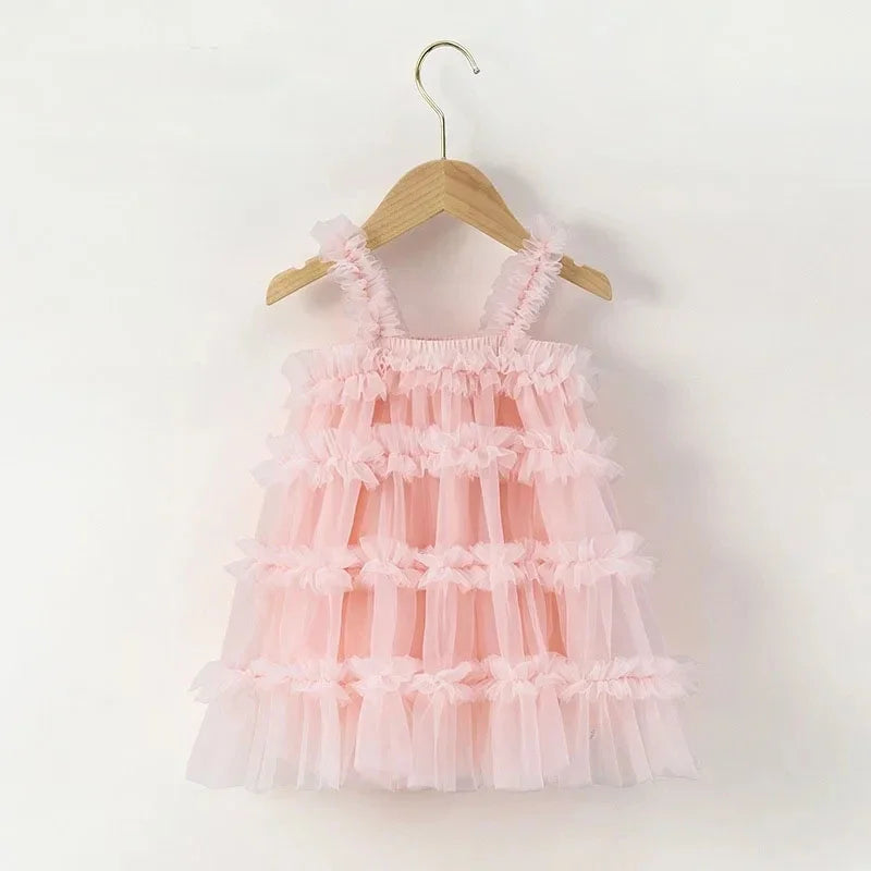 Pink ruffled dress on a wooden hanger against a white background