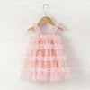 Pink ruffled dress on a wooden hanger against a white background