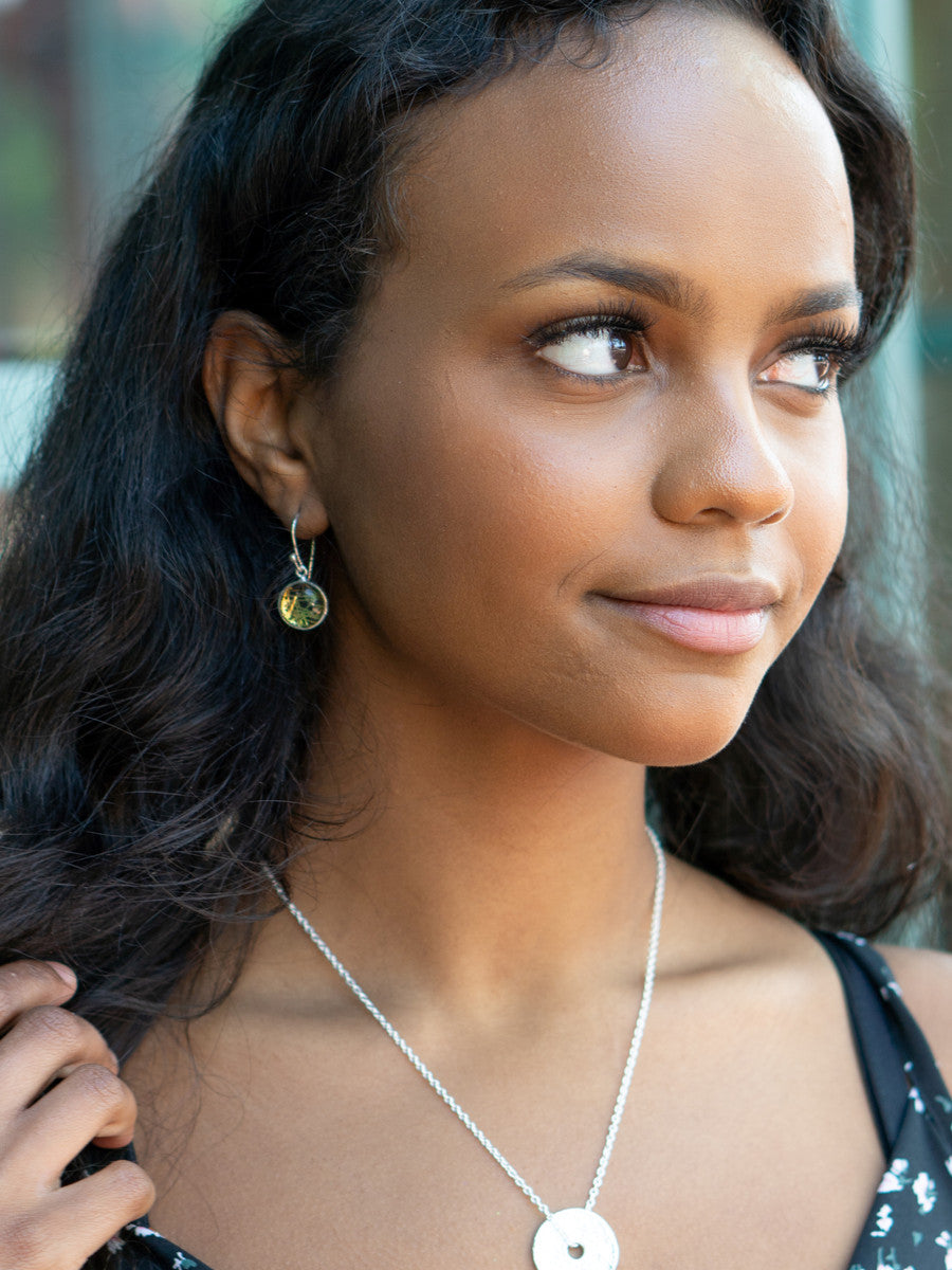 Close-up of silver drop earrings featuring natural rutilated quartz stone by Fair Anita