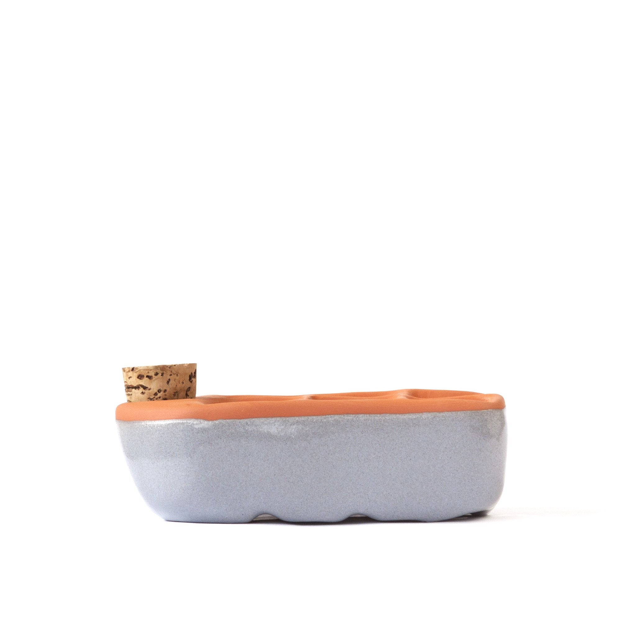 Ceramic planter with terracotta top and cork base on a white background